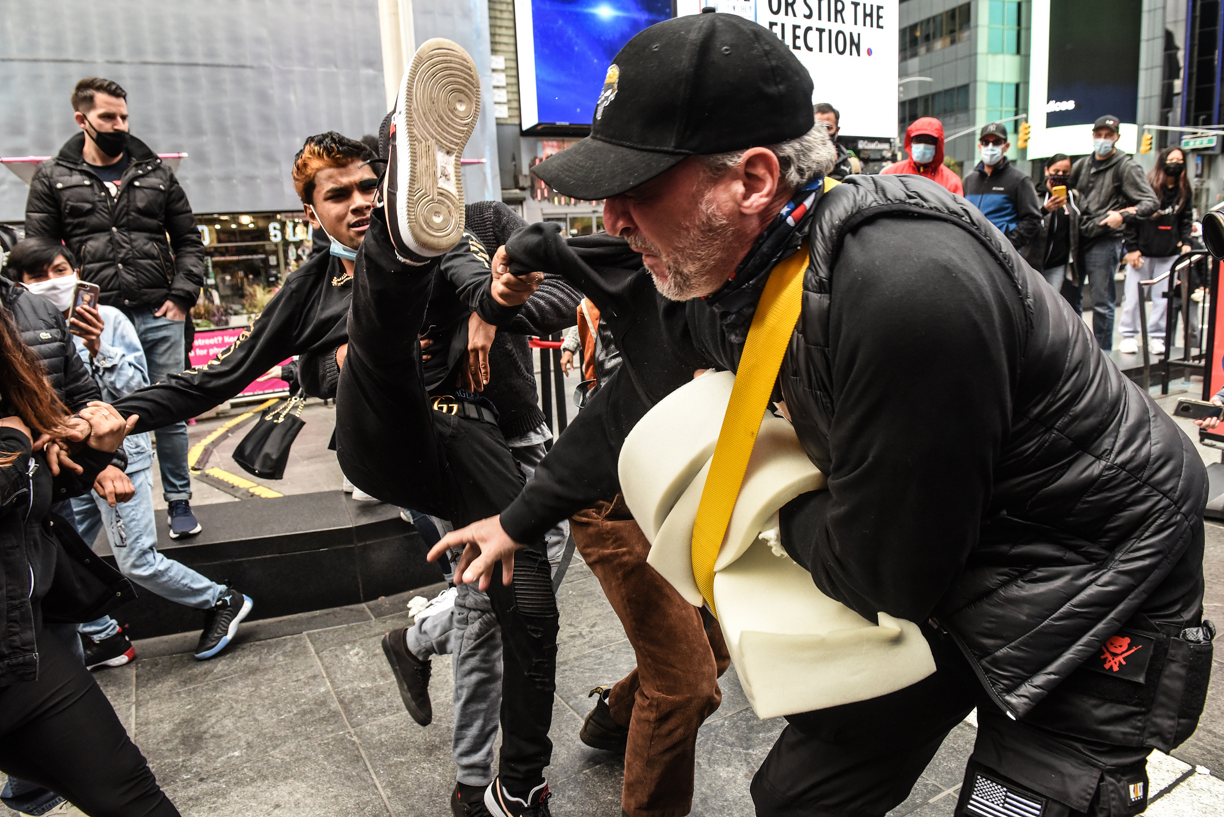 Trump supporter is kicked by a counter protester during a pro-Trump rally in Times Square in New York, New York, U.S. October 25, 2020. Several counter protesters were arrested during the afternoon of clashes in Times Square.